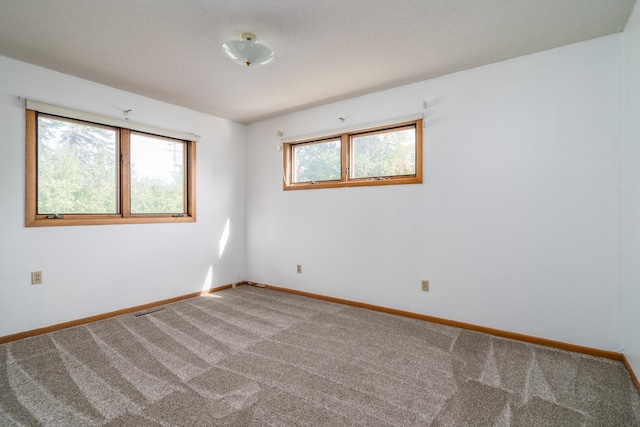 carpeted spare room featuring baseboards