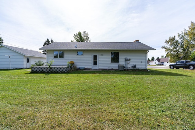 rear view of property featuring a yard, a chimney, and cooling unit