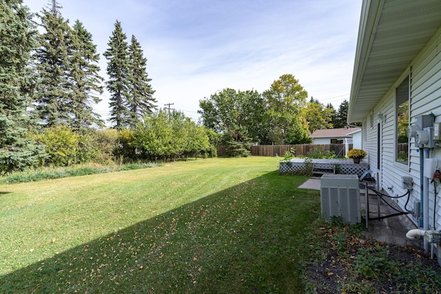 view of yard with fence and central AC unit