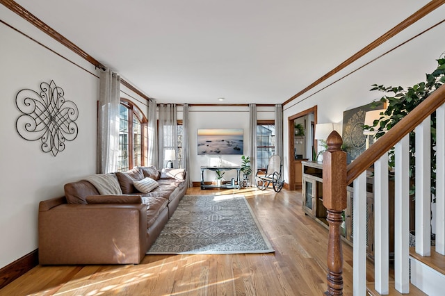 living area featuring baseboards, wood finished floors, and ornamental molding