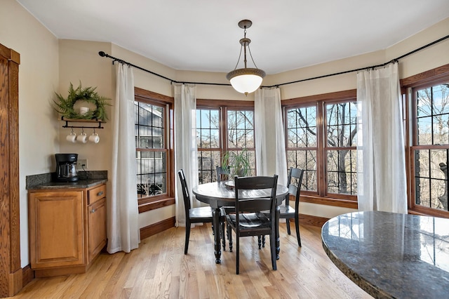 dining space featuring light wood-type flooring and baseboards