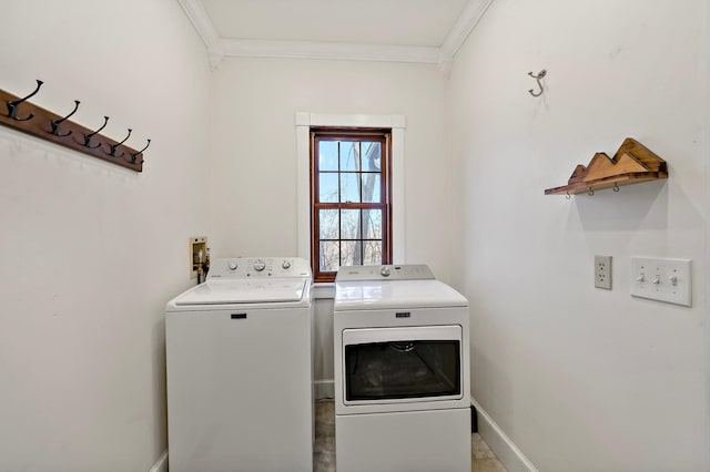 clothes washing area featuring laundry area, washing machine and dryer, crown molding, and baseboards