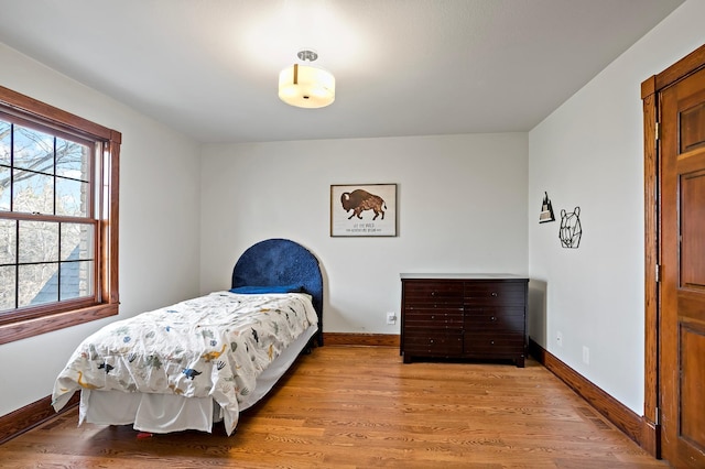 bedroom featuring baseboards and light wood finished floors