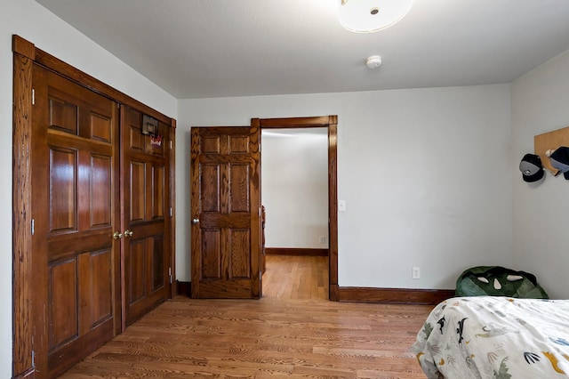 bedroom with baseboards and light wood-type flooring