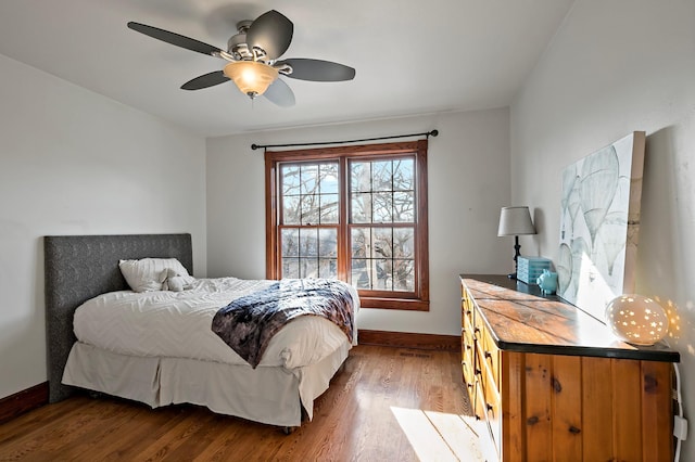 bedroom with wood finished floors, baseboards, and ceiling fan