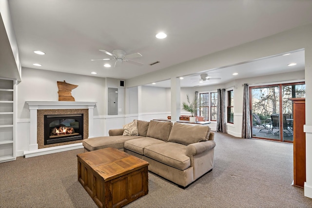 carpeted living room with a glass covered fireplace, recessed lighting, visible vents, and ceiling fan