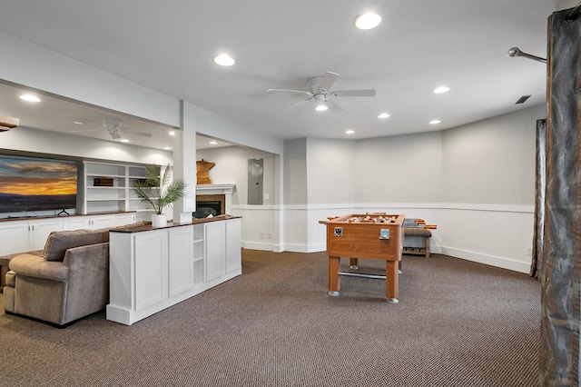 rec room featuring visible vents, dark carpet, recessed lighting, a fireplace, and a ceiling fan