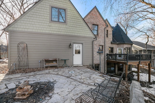 rear view of house with a patio area, brick siding, and a deck