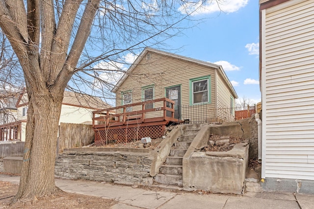 rear view of property with fence and a deck