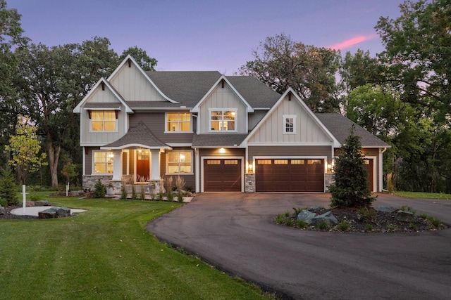 craftsman-style home featuring stone siding, aphalt driveway, a lawn, and board and batten siding