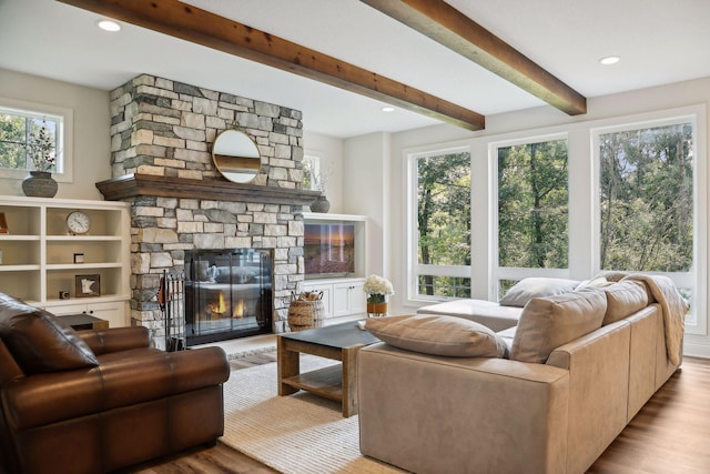 living area featuring recessed lighting, a fireplace, beamed ceiling, and wood finished floors