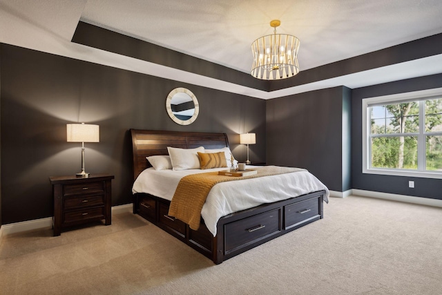 bedroom with light carpet, baseboards, a chandelier, and a tray ceiling