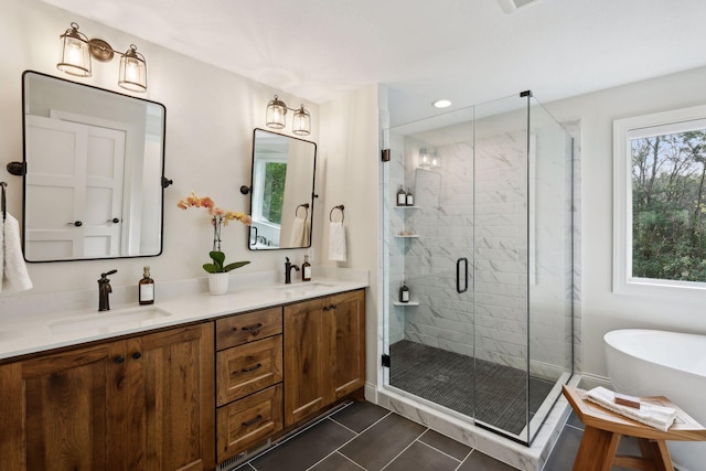 bathroom with double vanity, a sink, a shower stall, and tile patterned floors