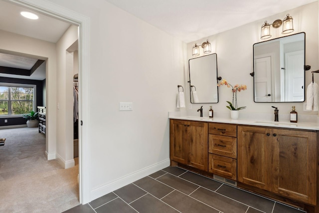 bathroom featuring double vanity, tile patterned flooring, baseboards, and a sink