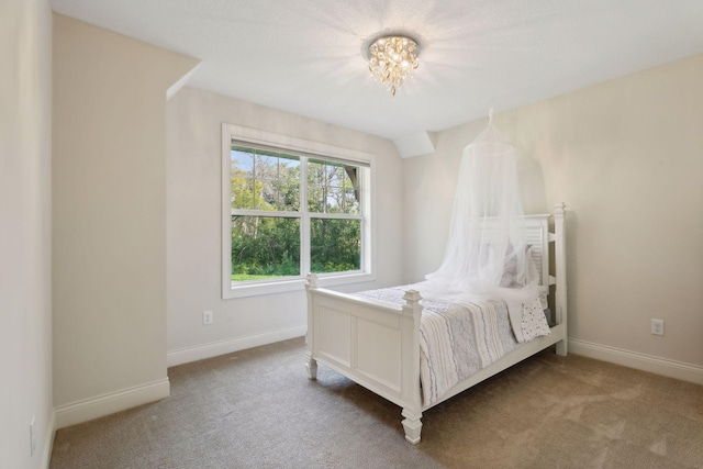 carpeted bedroom with a chandelier and baseboards