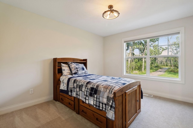 bedroom featuring light colored carpet, visible vents, and baseboards