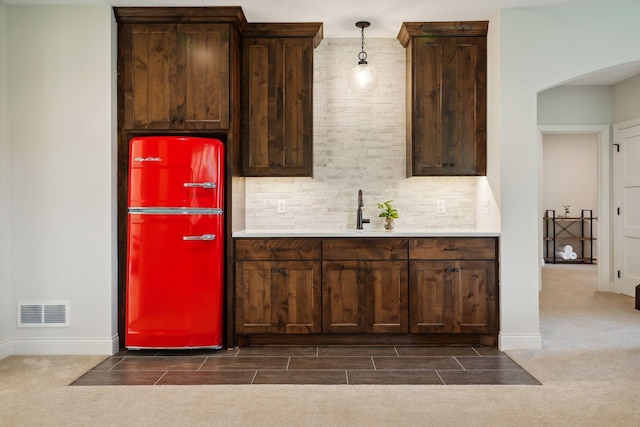 kitchen with visible vents, decorative backsplash, a sink, and light countertops