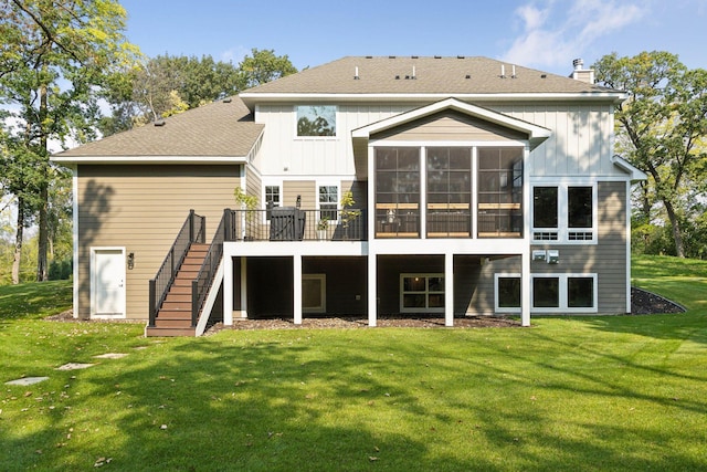 rear view of house featuring a deck, a sunroom, stairs, a lawn, and a chimney