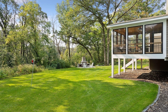 view of yard featuring a sunroom and a fireplace