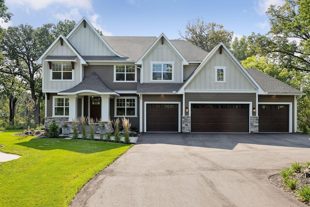 craftsman house featuring a shingled roof, driveway, stone siding, board and batten siding, and a front yard