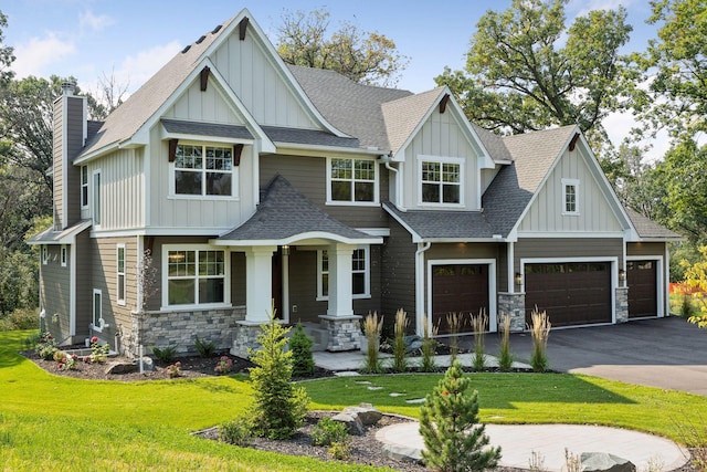 craftsman-style home with a garage, stone siding, roof with shingles, board and batten siding, and a front yard