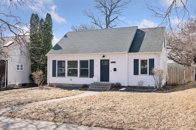 cape cod-style house with roof with shingles and fence