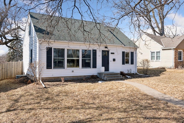 view of front of property with roof with shingles and fence