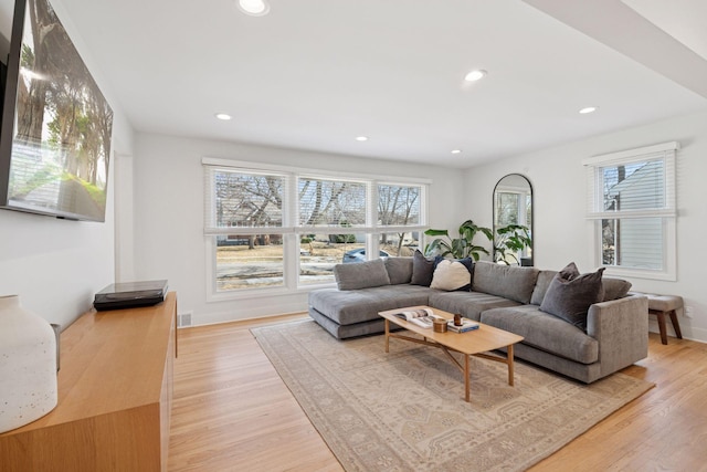 living area with visible vents, recessed lighting, light wood-style floors, and baseboards