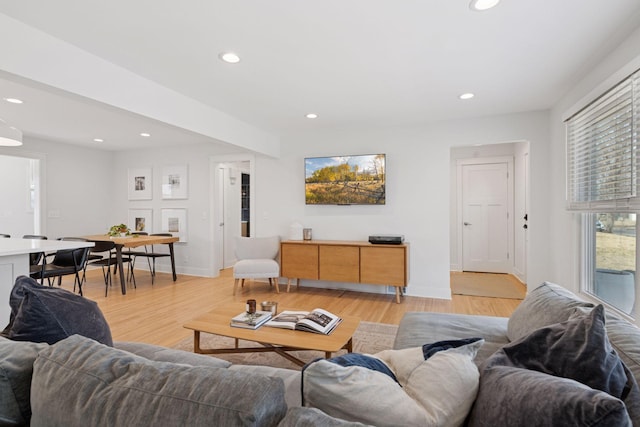 living room featuring light wood finished floors, recessed lighting, and baseboards