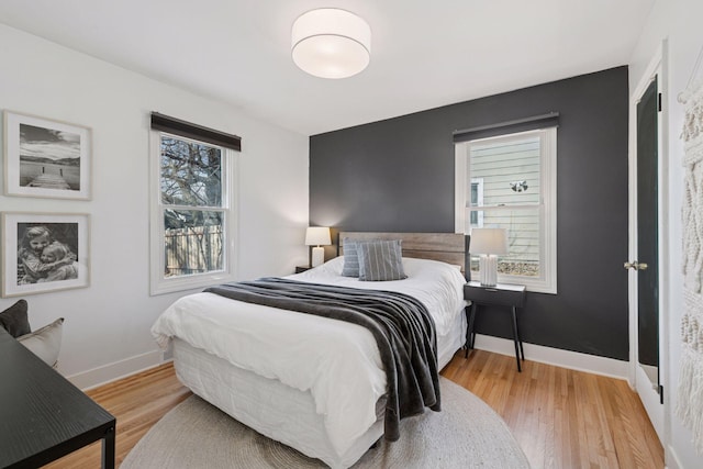 bedroom with light wood-type flooring and baseboards