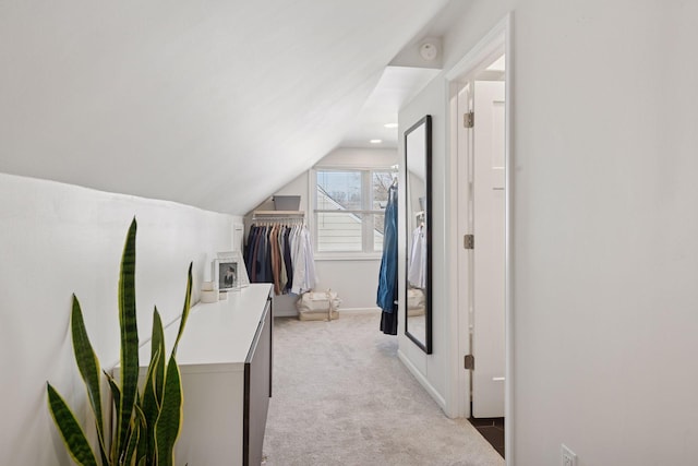 hallway with light carpet, recessed lighting, baseboards, and vaulted ceiling