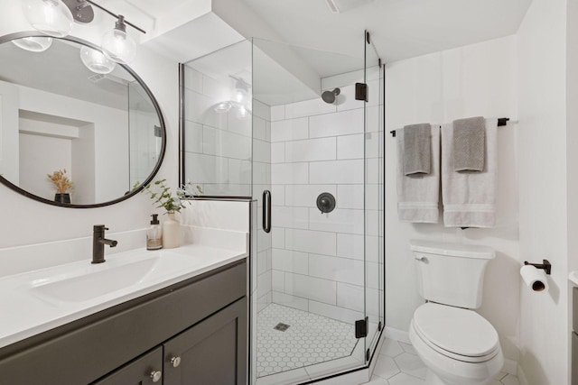 bathroom featuring a shower stall, toilet, vanity, and baseboards