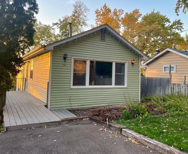 back of property with a wooden deck and fence