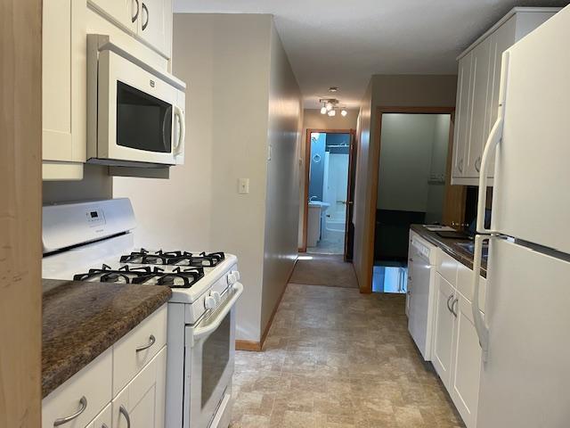 kitchen featuring white cabinets and white appliances