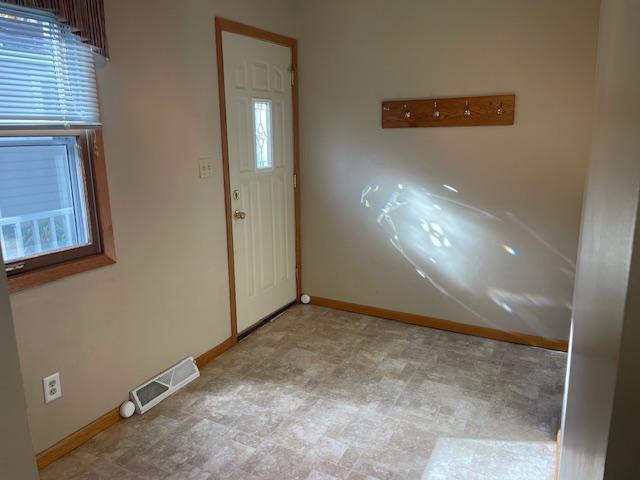 entryway featuring visible vents, baseboards, and light floors