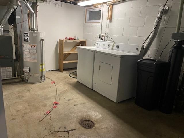 laundry room with washer and dryer, laundry area, concrete block wall, and water heater