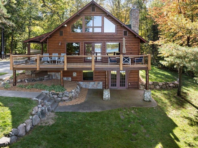 back of property featuring a wooden deck, a yard, a chimney, french doors, and a patio area