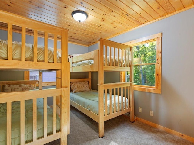 carpeted bedroom featuring wooden ceiling and baseboards