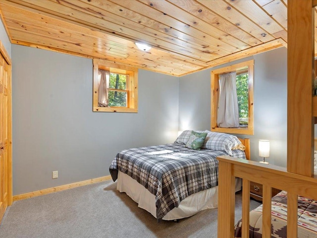 bedroom with baseboards, carpet floors, and wooden ceiling