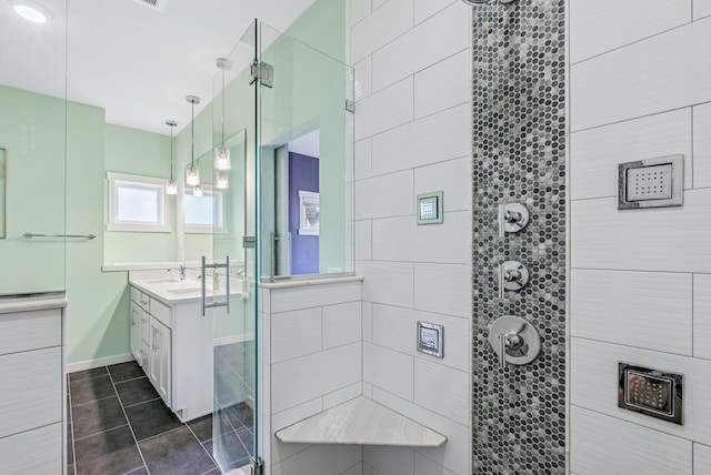 full bath with vanity, a shower stall, baseboards, and tile patterned flooring