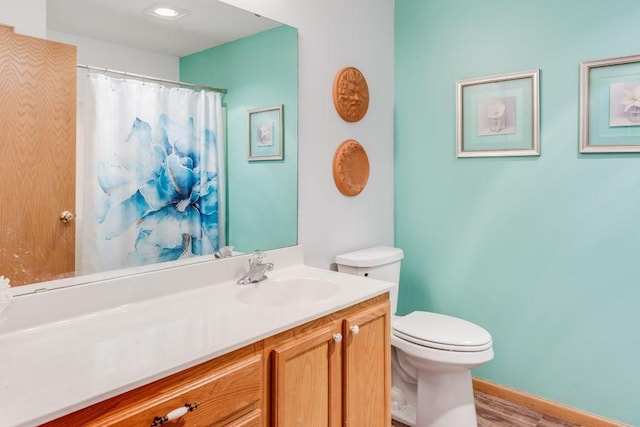 bathroom with a shower with curtain, baseboards, vanity, and toilet