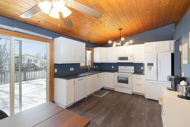 kitchen with dark wood-type flooring, a sink, dark countertops, white appliances, and vaulted ceiling