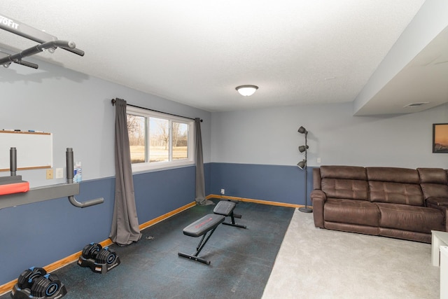 exercise area with visible vents, a textured ceiling, and baseboards