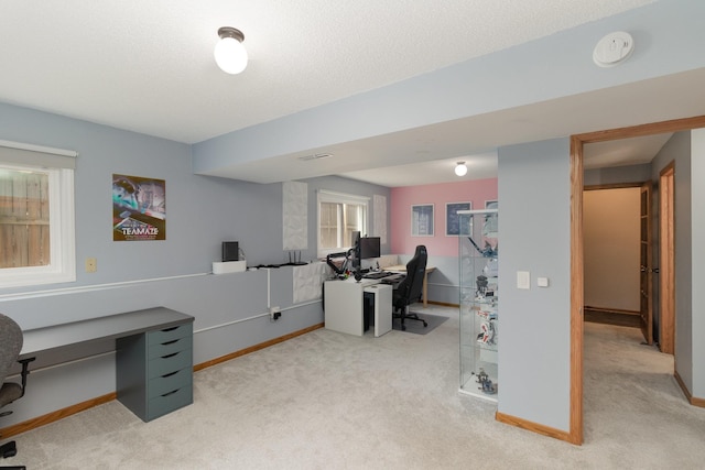 carpeted home office with a textured ceiling and baseboards