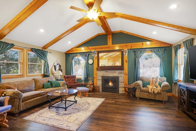 living room featuring a healthy amount of sunlight, a stone fireplace, lofted ceiling with beams, and wood finished floors