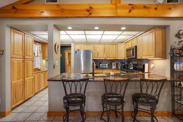 kitchen with stainless steel appliances, a breakfast bar, a peninsula, and a sink