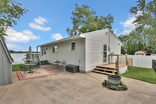 back of property with a deck, a patio area, and fence