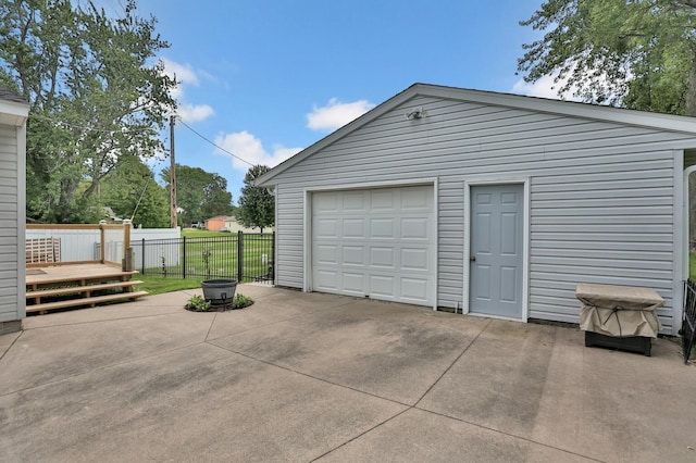 garage with driveway and fence