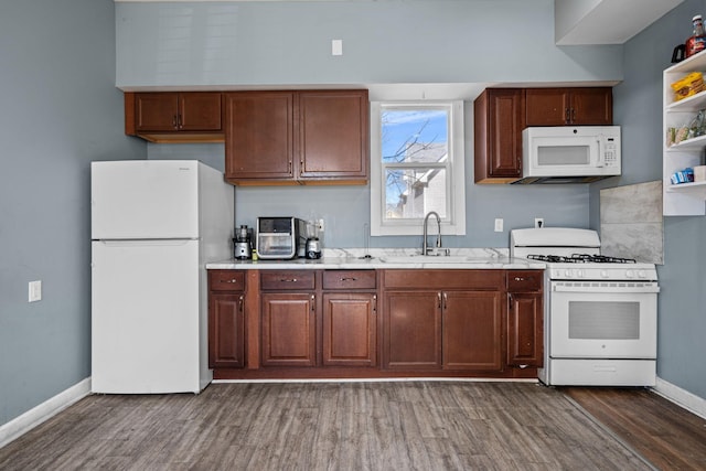 kitchen featuring dark wood-style floors, open shelves, a sink, white appliances, and baseboards