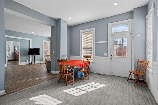 dining area with recessed lighting, wood finished floors, and wainscoting